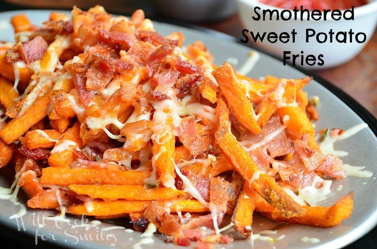 close up shot of smothered sweet potato fries with white sauce cup to right in background