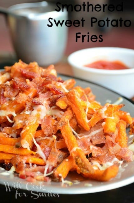 close up shot of smothered sweet potato fries with white sauce cup to right in background