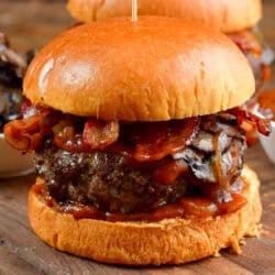 one burger on the bun with sauteed mushrooms, bacon, and whiskey sauce.