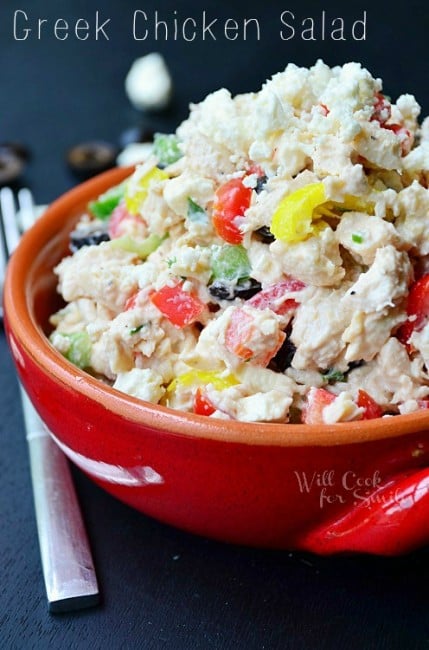 closer view of chicken salad in a red bowl with a fork next to it