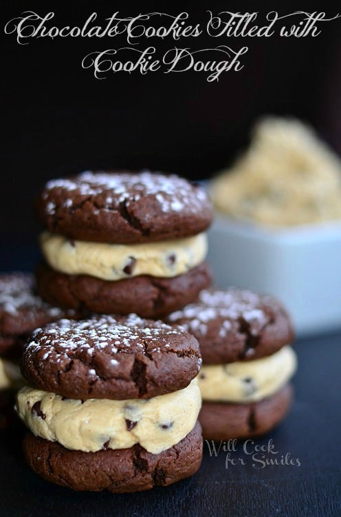 several chocolate cookies filled with chocolate chip cookie dough and white square bowl with cookie dough to left of cookies