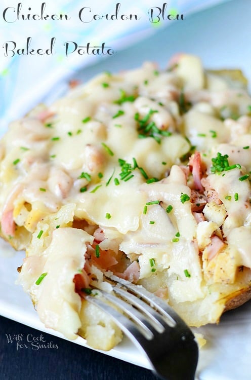 Chicken Cordon Bleu Baked Potato on a white plate with a fork 