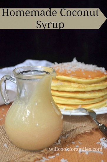 coconut syrup in a pitcher with coconut pancakes in the background 