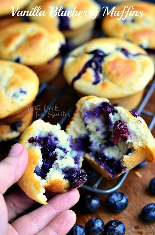 Vanilla Blueberry Muffins on a cooling wrack and tearing one apart 