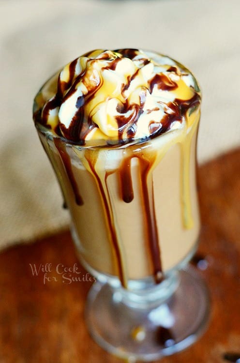 View from above of a chocolate caramel frozen coffee drink in a dessert glass on a wooden table