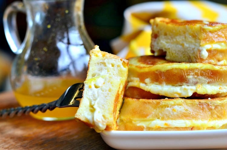 Orange Creamsicle French Toast with a bite on a fork and syrup in the background 