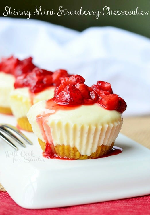 Mini Strawberry Cheesecakes on a white plate with strawberries on top 