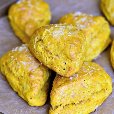 8 savory three cheese cream cheese scones on a piece of wax paper on a wooden table