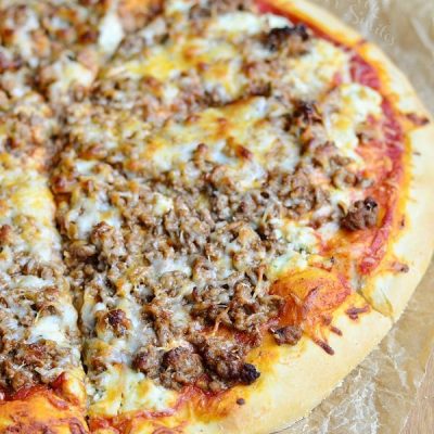 view from above of homemade lasagna pizza on wax paper and wooden table