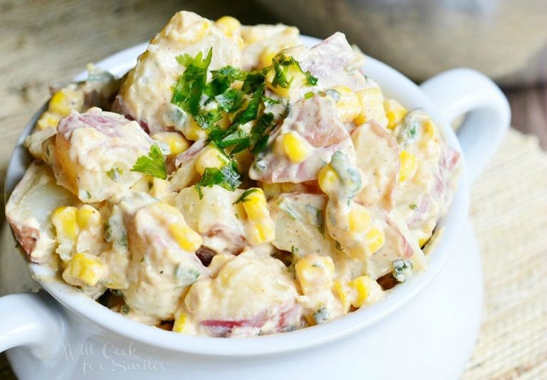 view from above of chipotle ranch potato salad in a white crock on a wooden table