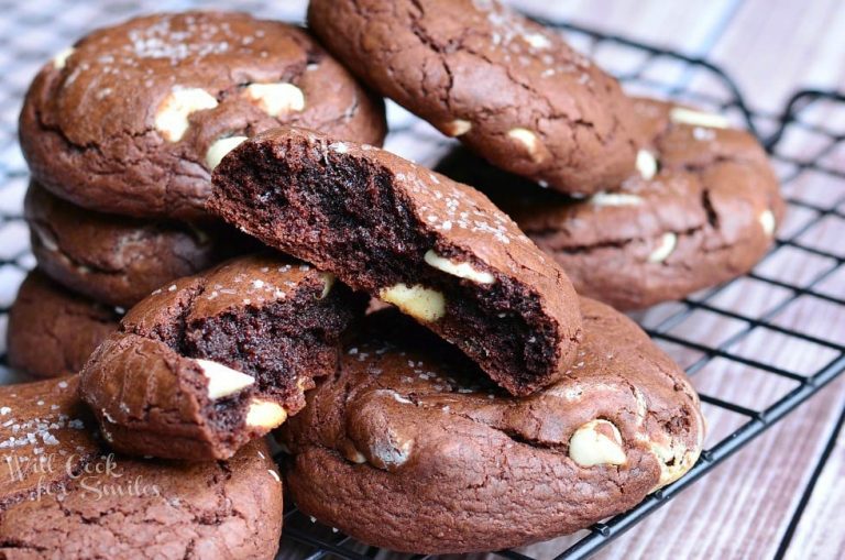 close up view of view from above of salted chocolate white chocolate chip cookies on a wire cooling rack on top of a wooden table and top cookie broken into 2