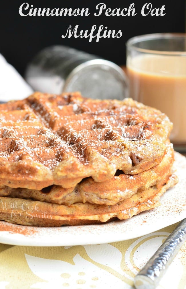 3 stacked cinnamon peach oat waffles on a white plate with a glass of coffe in the background