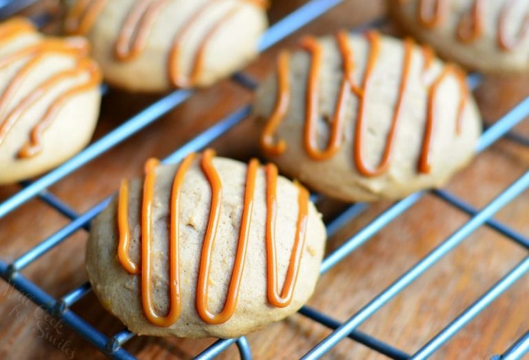 pumpkin dulce de leche nutella cookies on a metal cooling rack on top of a wooden table as viewed close up