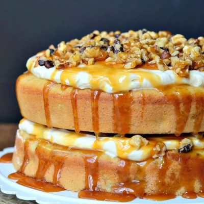 whole caramel banana nut cake on a white cake plate