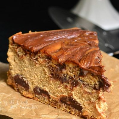 1 slice of gingerbread nutella swirl cheesecake in front of a cake stand with additional cake