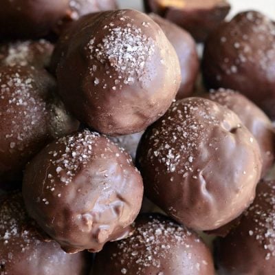 Salted almond fudge truffles piled on a decorative white plate as viewed close up and from above