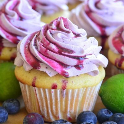 key lime cupcake with blueberry frosting and blueberries around the cupcake.