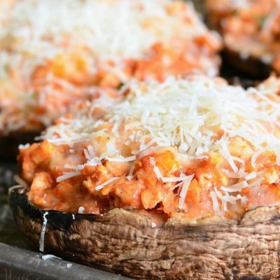 3 chicken parmesan stuffed portobello on a baking sheet tray