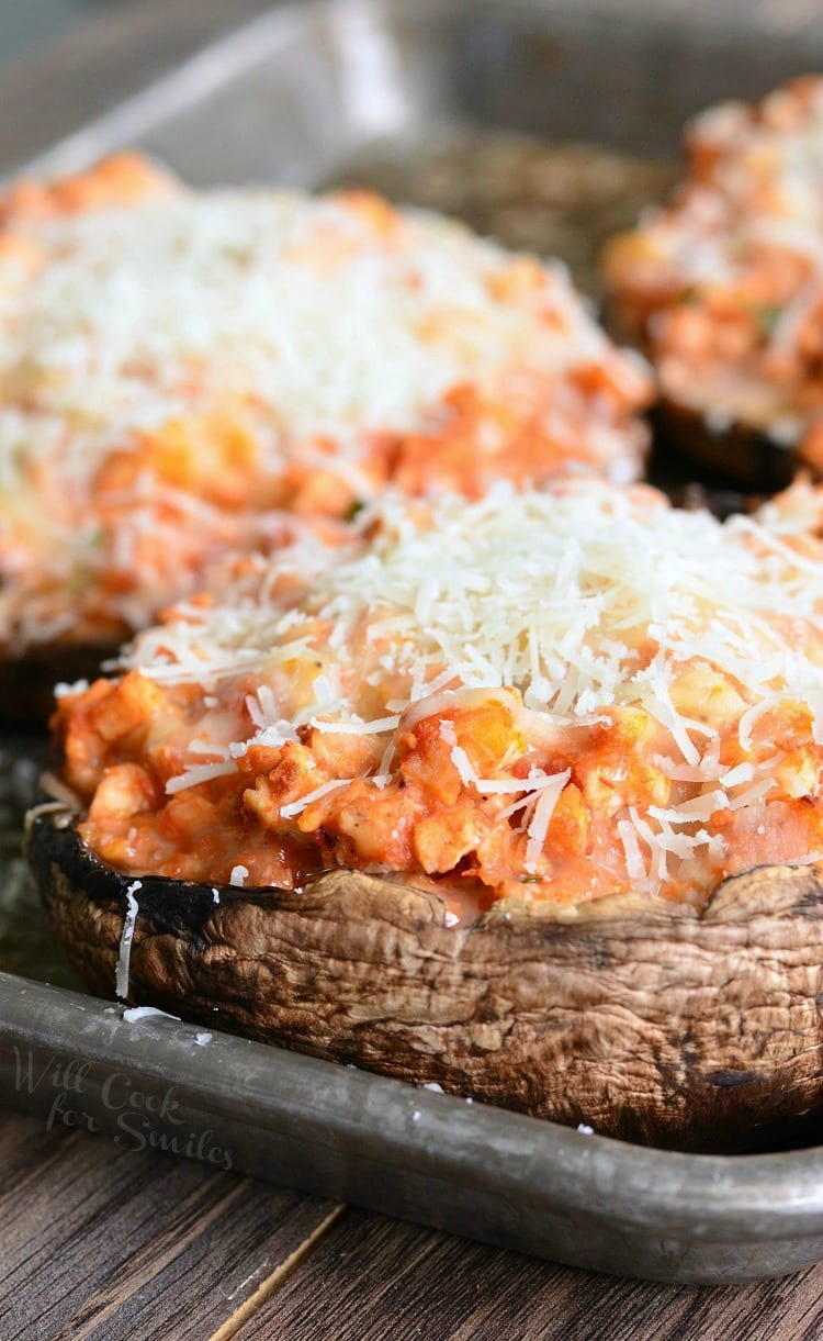 3 chicken parmesan stuffed portobello on a baking sheet tray