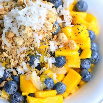 White bowl filled with mango lychee and blueberry fruit bowl as viewed from above