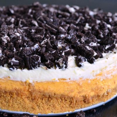 Layered Oreo Pumpkin Cheesecake on a black table as viewed close up