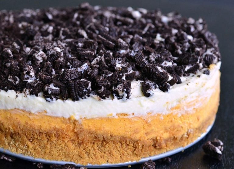 Layered Oreo Pumpkin Cheesecake on a black table as viewed close up