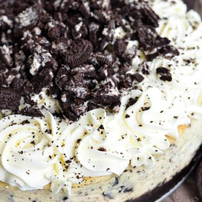 Ultimate Oreo Cheesecake on a round pie tray with Oreo cookies around the base of the cake as viewed from above.