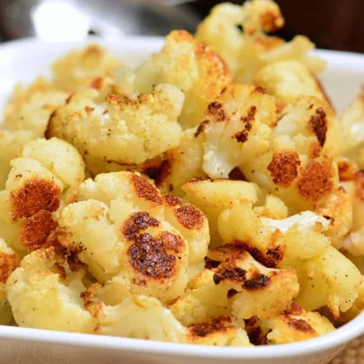 roasted pieces of cauliflower in a white bowl.