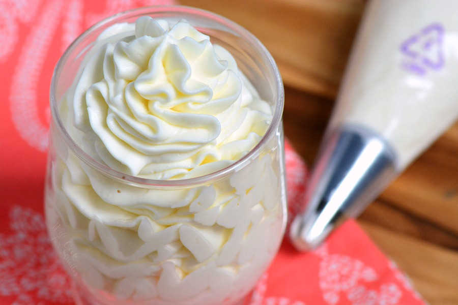 3 Ingredient Frosting pipped into a glass sitting on a table with pipping bag 