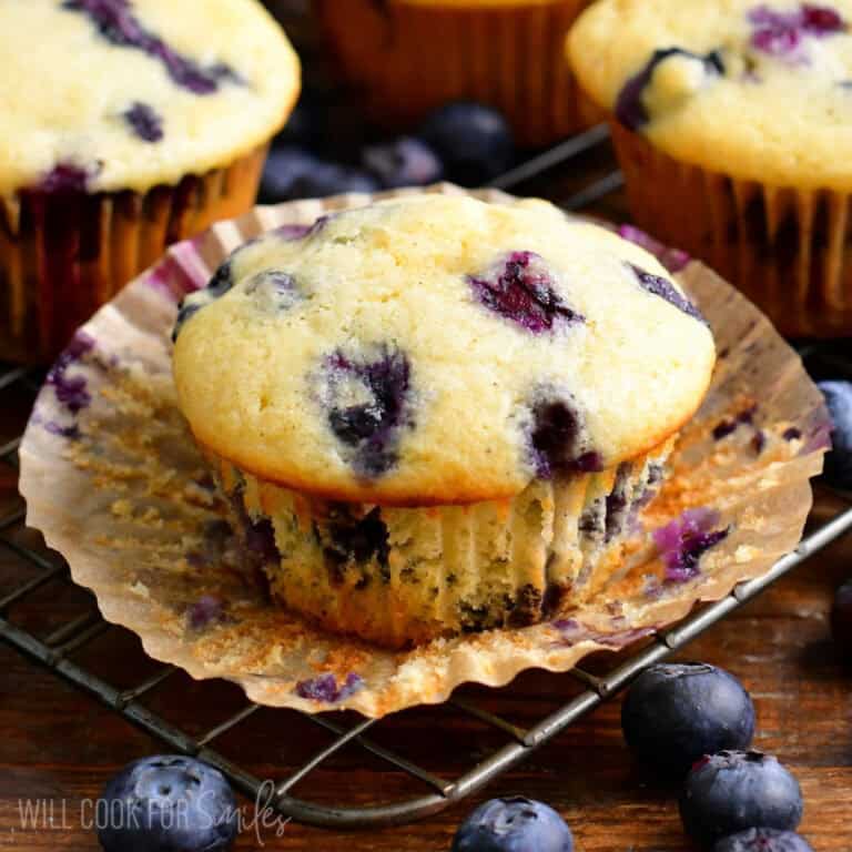 one blueberry muffin on a cooling wire rack with wrapper taken off.