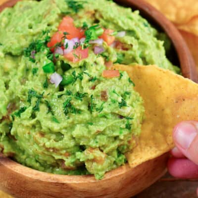 closeup of scooping guac with a chip.