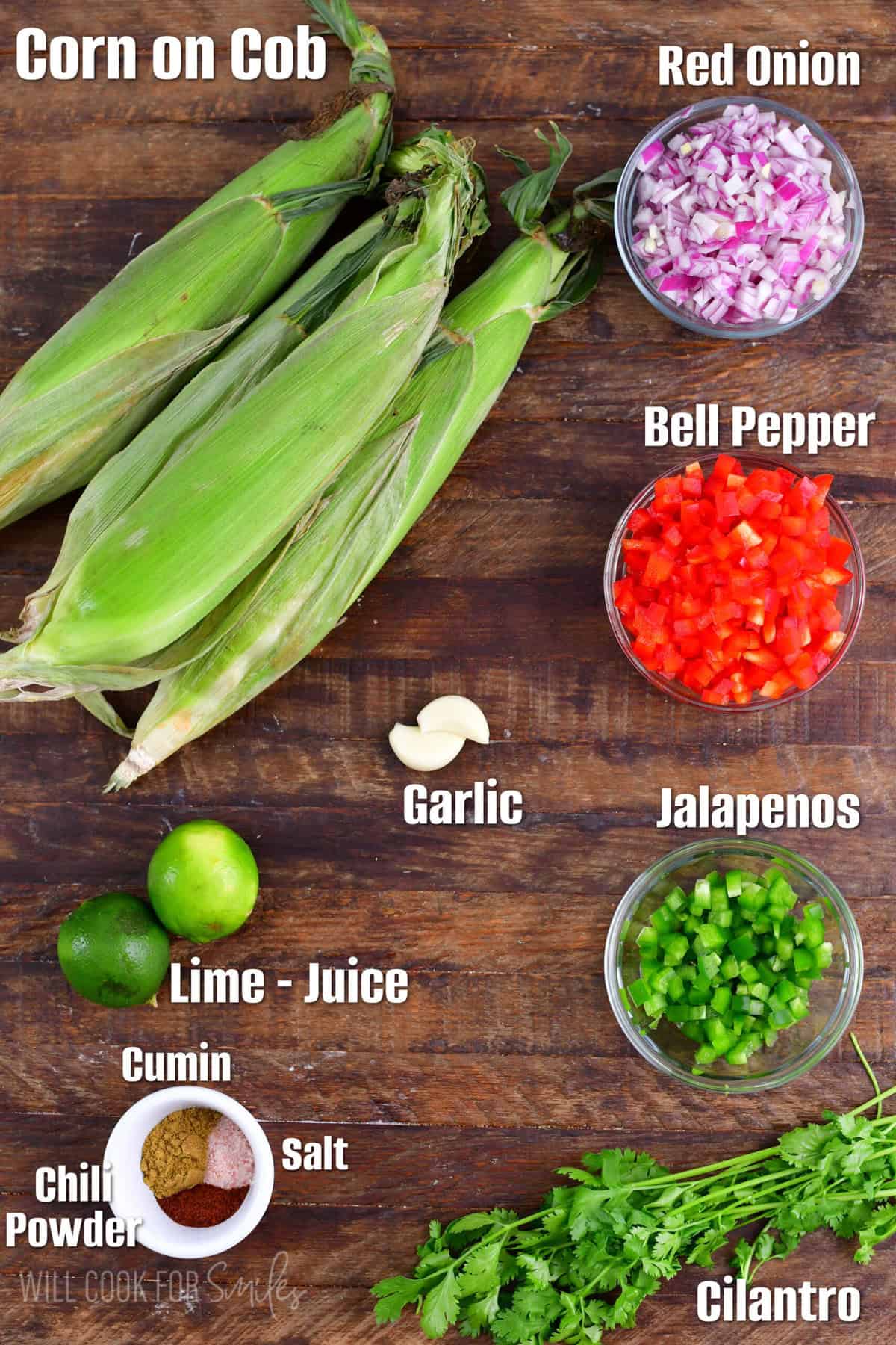 Labeled ingredients for corn salsa on a wood surface.