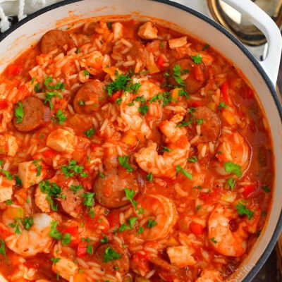 top view of jambalaya in a white Dutch oven pot with a ladle next to the pot