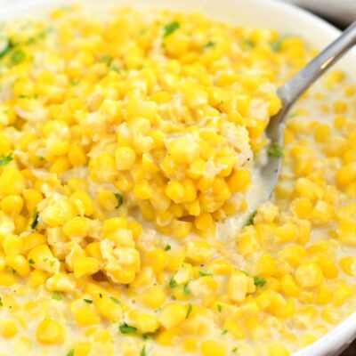 overhead closeup: spoonful of creamed corn in a bowl