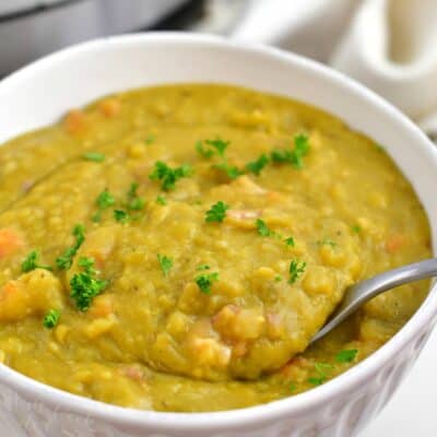 closeup image: thick green split pea soup in white bowl