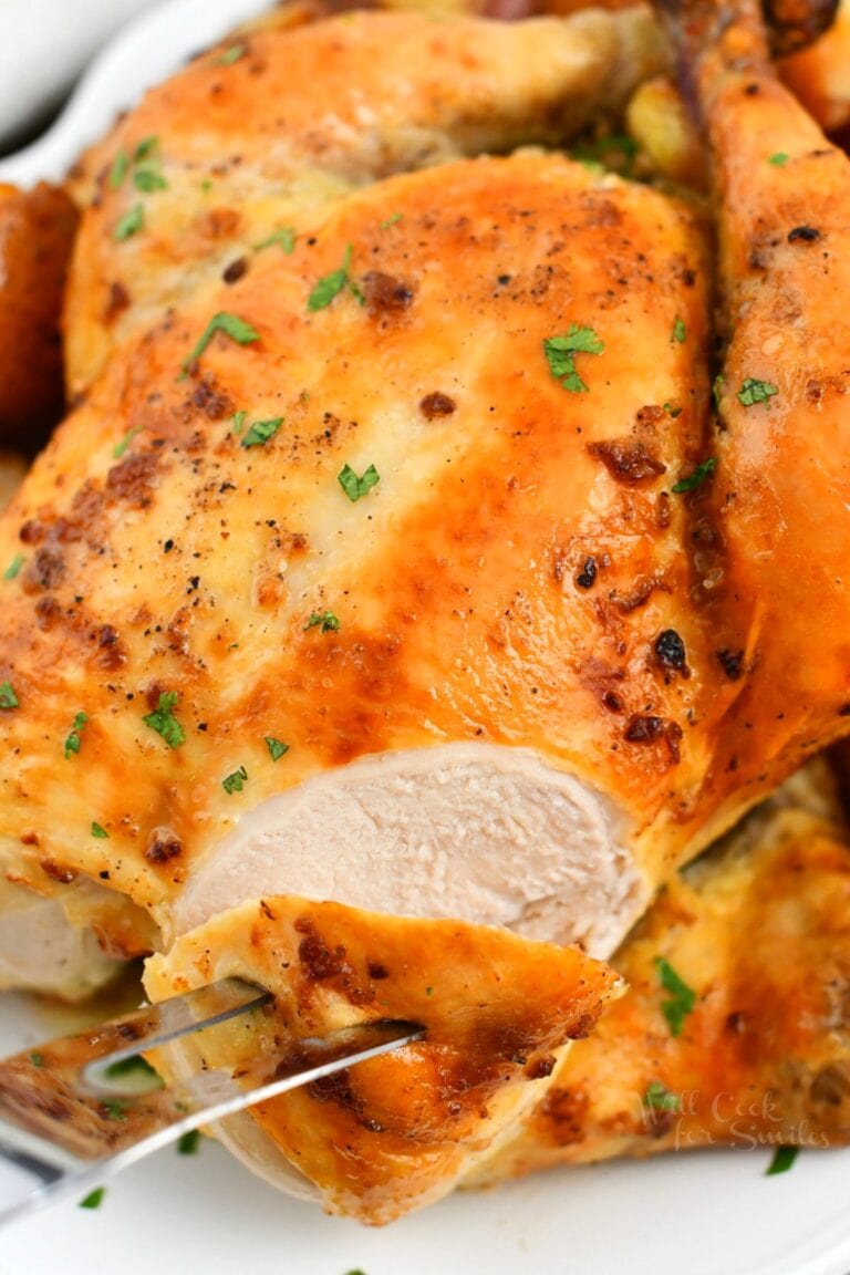 close up photo: carving crispy skinned whole chicken