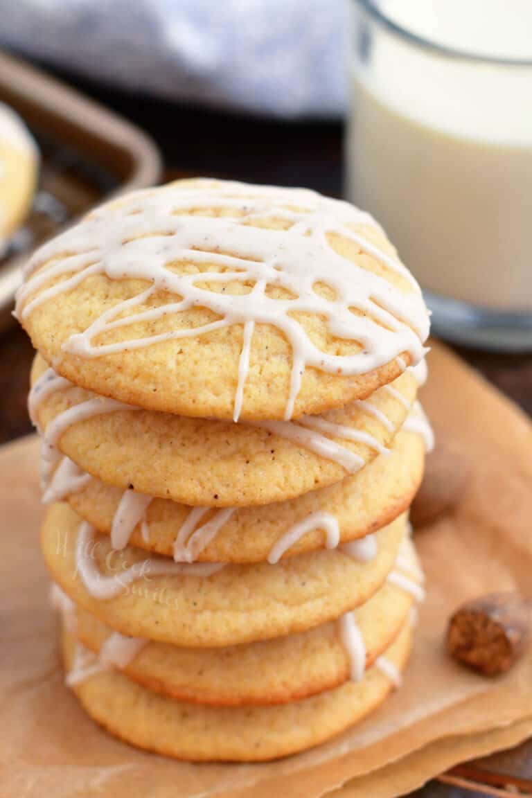 Eggnog cookies are stacked on top of an orange napkin.