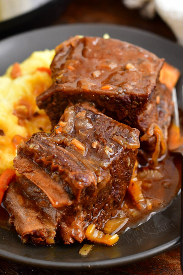 A serving of short ribs is served on top of mashed potatoes.