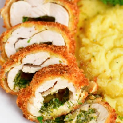 stuffed chicken breast cut into thin slices revealing herb butter inside