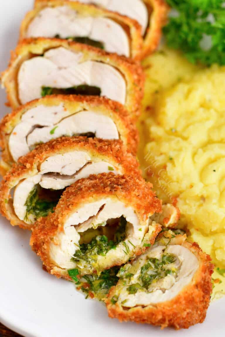 stuffed chicken breast cut into thin slices revealing herb butter inside