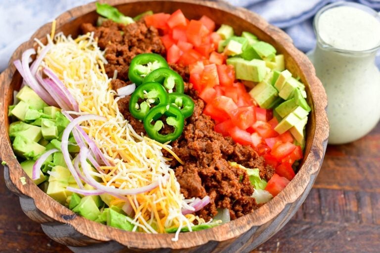 All of the ingredients for taco salad are lined up in a bowl.