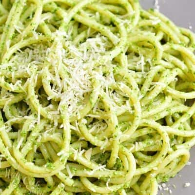 Pesto pasta is plated and sprinkled with parmesan.