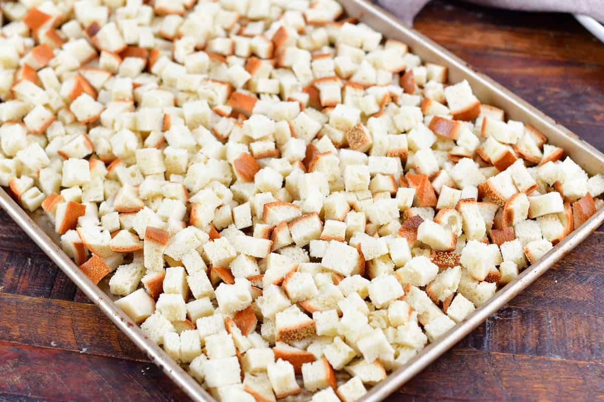 small cubes of bread spread on a baking sheet