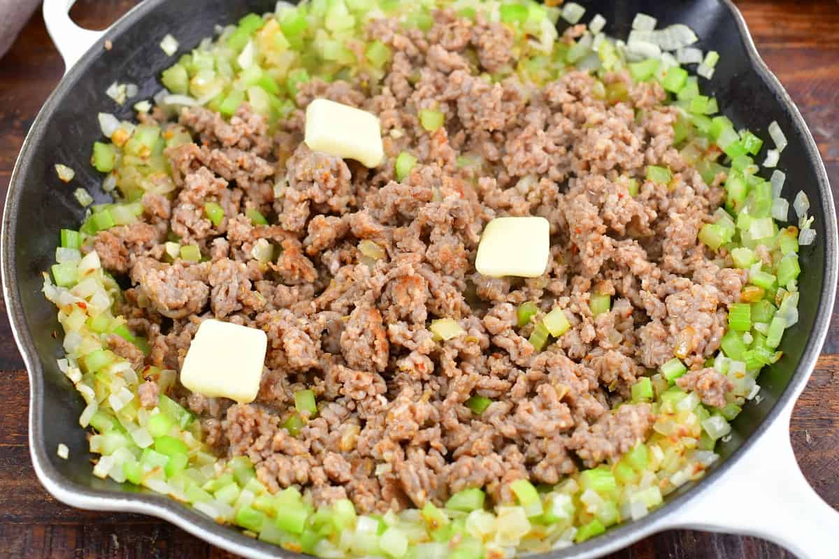 cooked ground sausage in the middle of the pan with veggies and butter