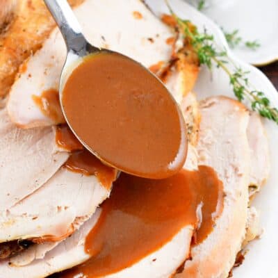 pouring gravy over sliced turkey breast