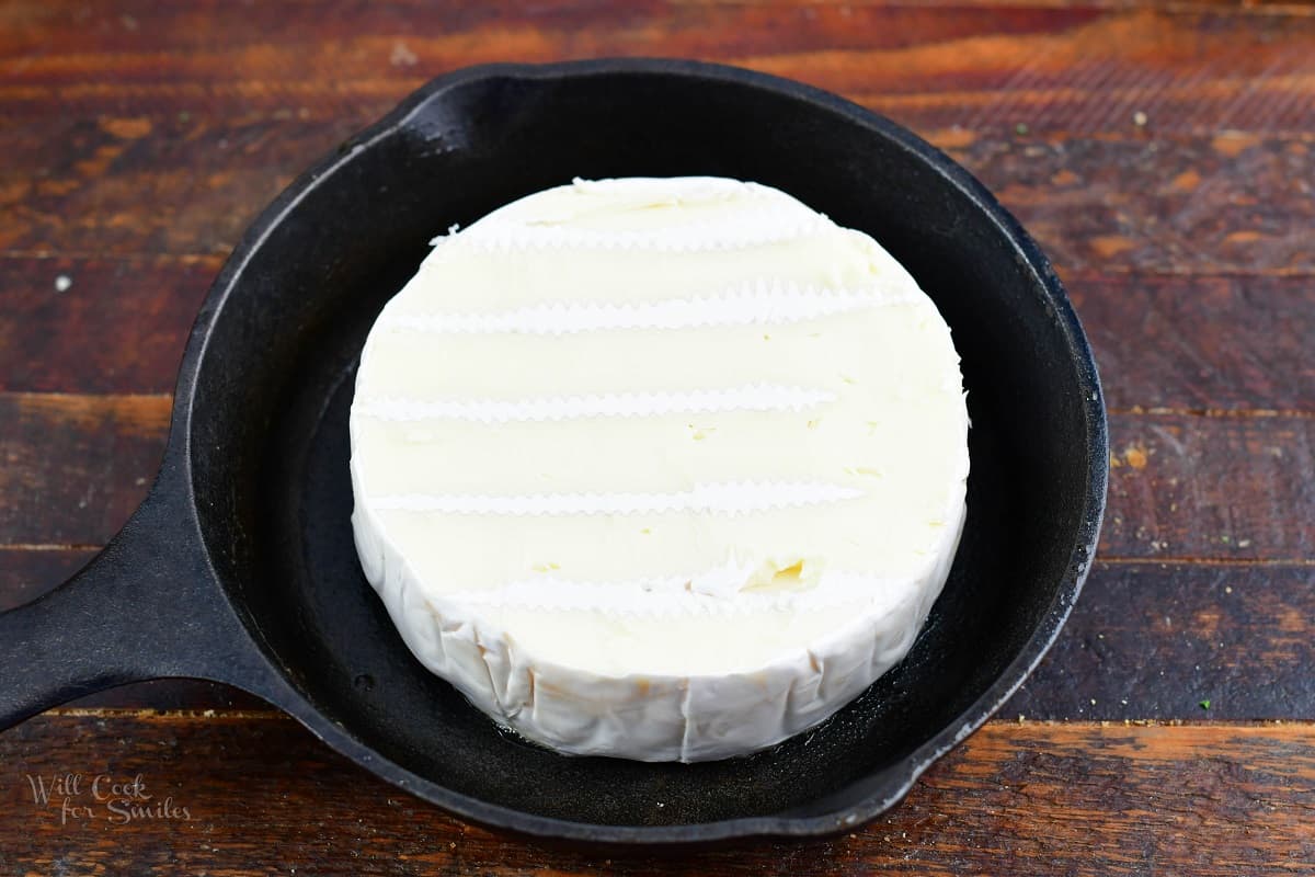 brie wheel in a small skillet with top cut off