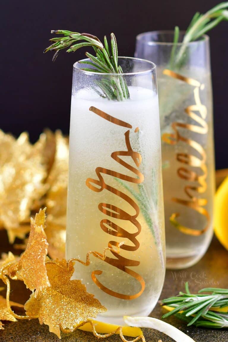 closeup of the tall glass with champagne cocktail and rosemary stick