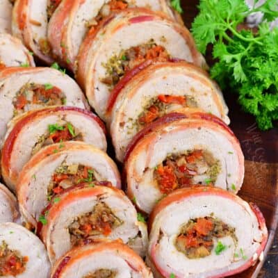 sliced stuffed pork tenderloin stacked side by side on a platter