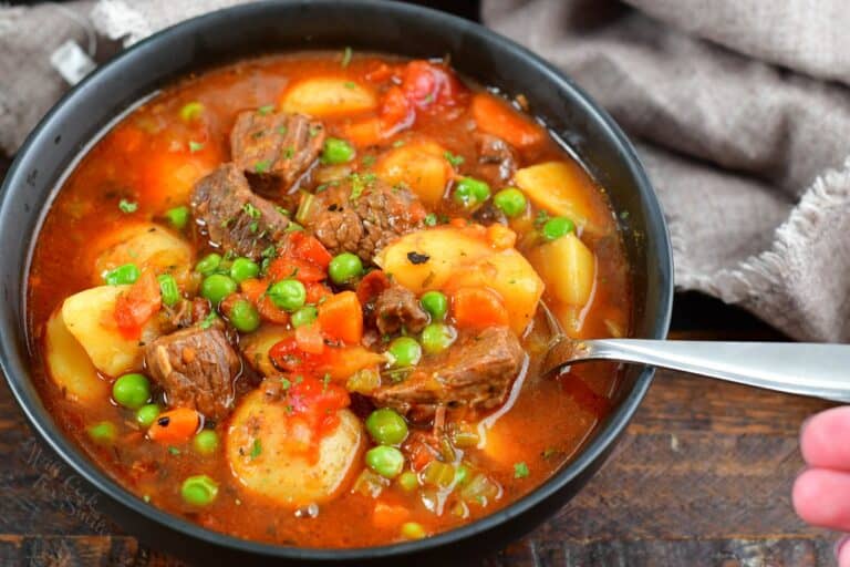 spooning some beef soup from a bowl