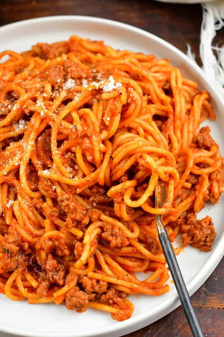 closeup of pasta with sauce and swirled on a fork